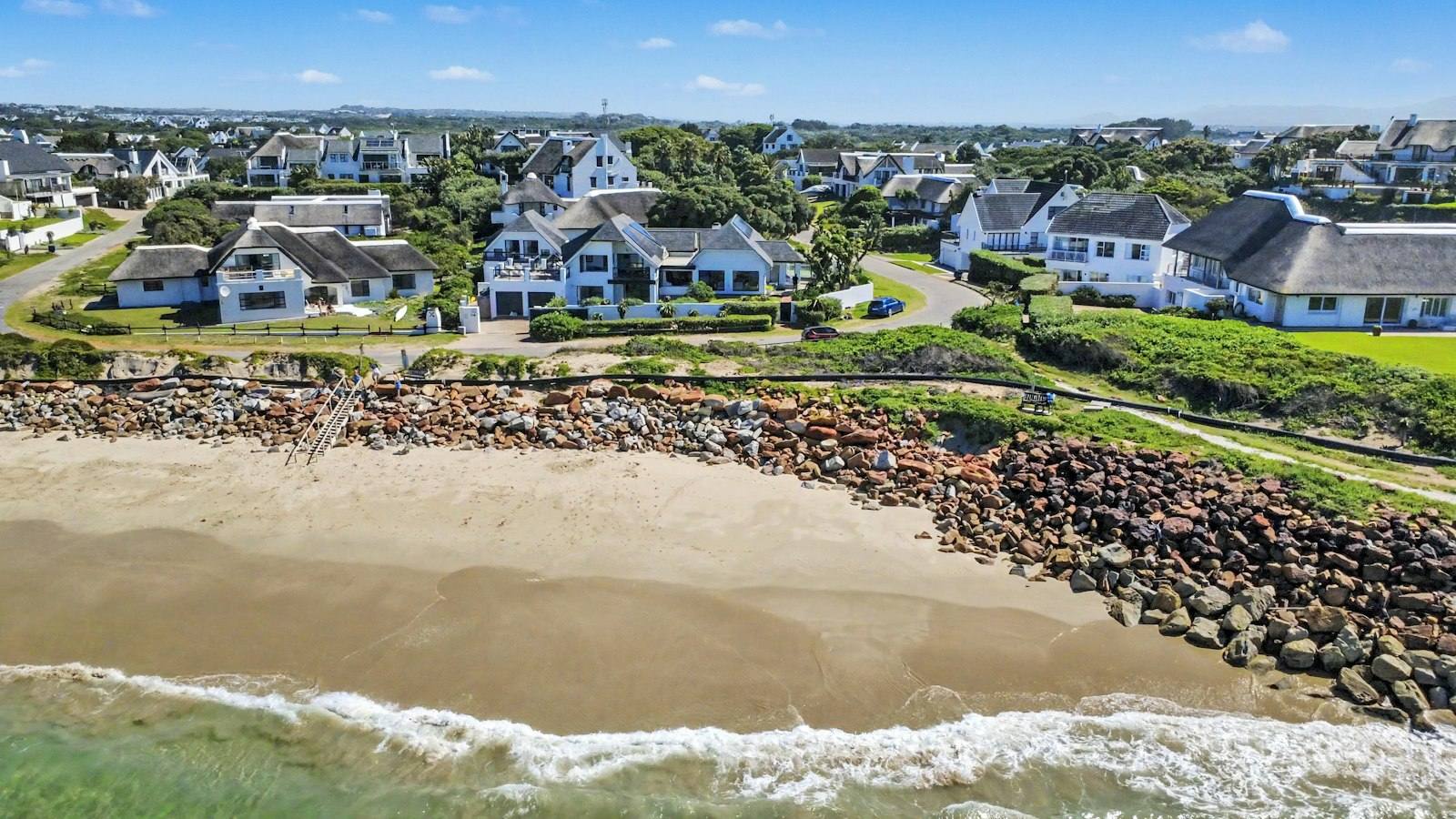 Aerial view of the beach with the white houses of St Francis Bay behind it