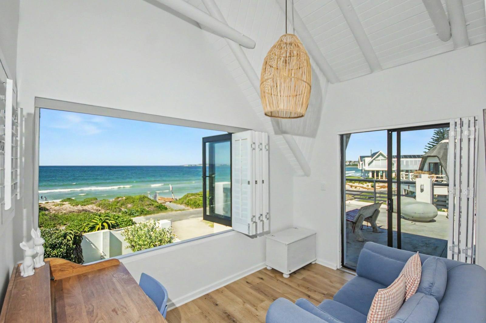 Main bedroom seating area with windows folded open to the sea